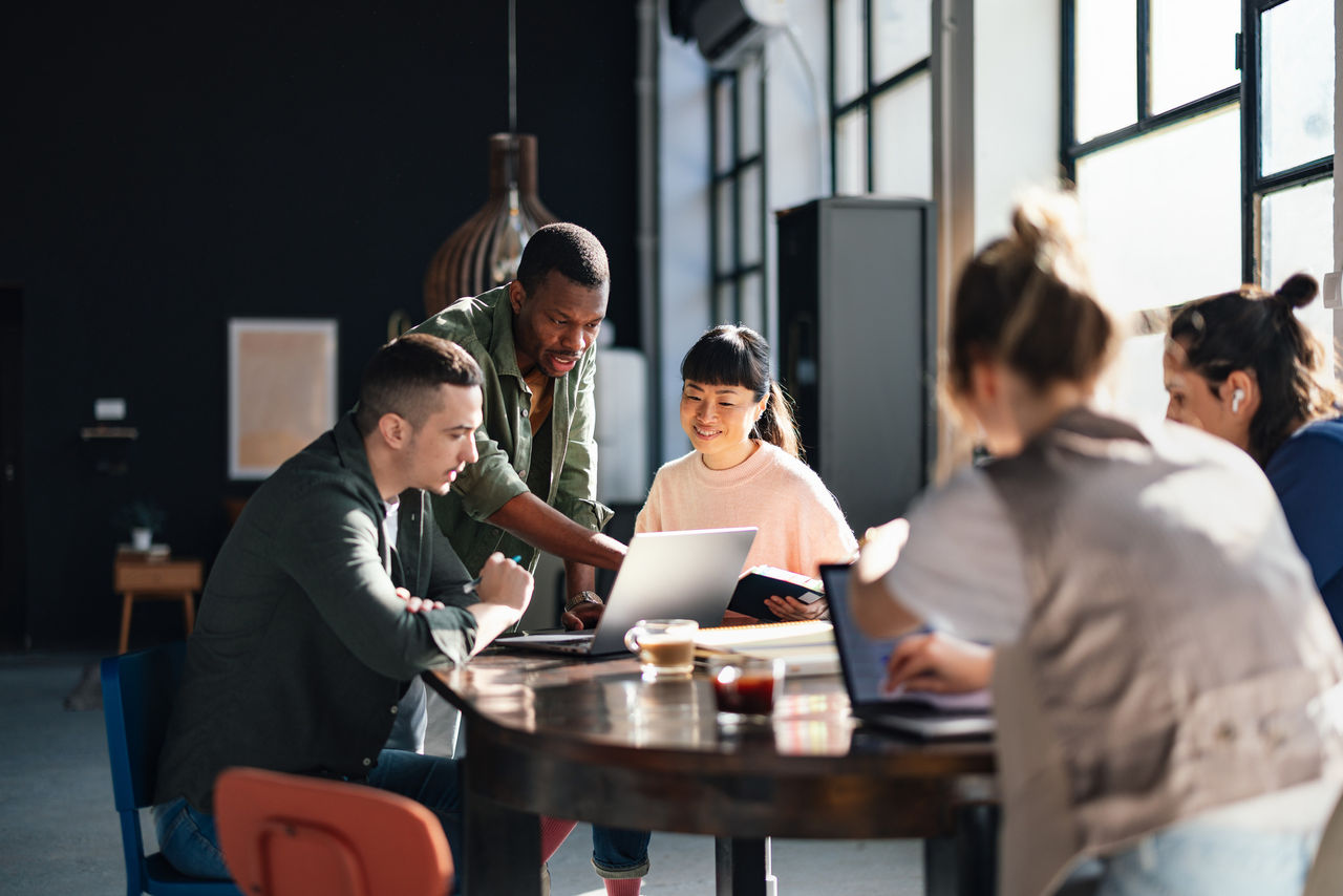 Five people sitting on table and having some discussion